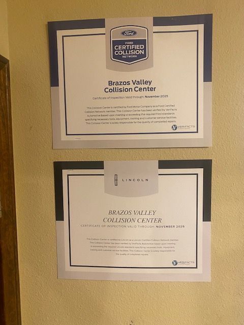 Two framed Beaverton Collision Center certificates on a beige wall, one with a small note above it.