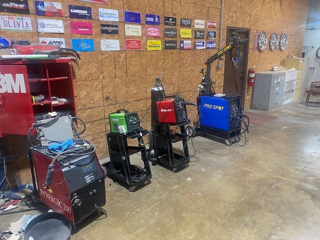 Row of pressure washers and cleaning equipment displayed against a wall in a workshop or store