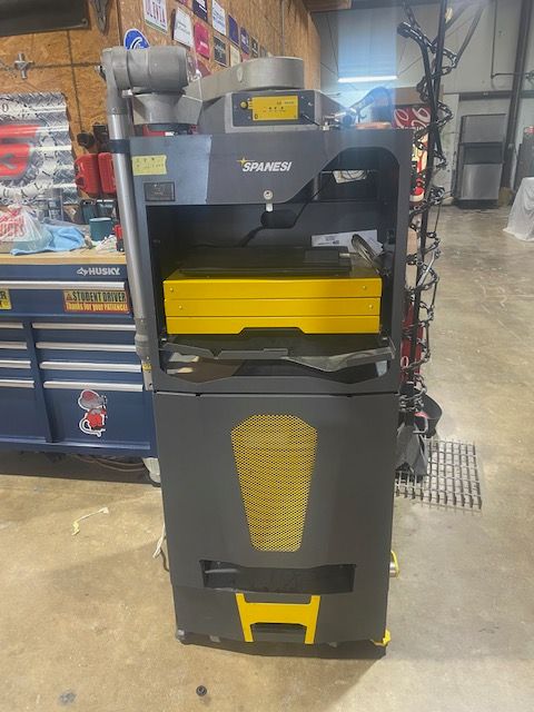 Gray and yellow Snap-on tool cabinet in a workshop, with drawers and power tools on top