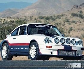 White and blue rally Porsche 911 on a road with desert mountains in the background
