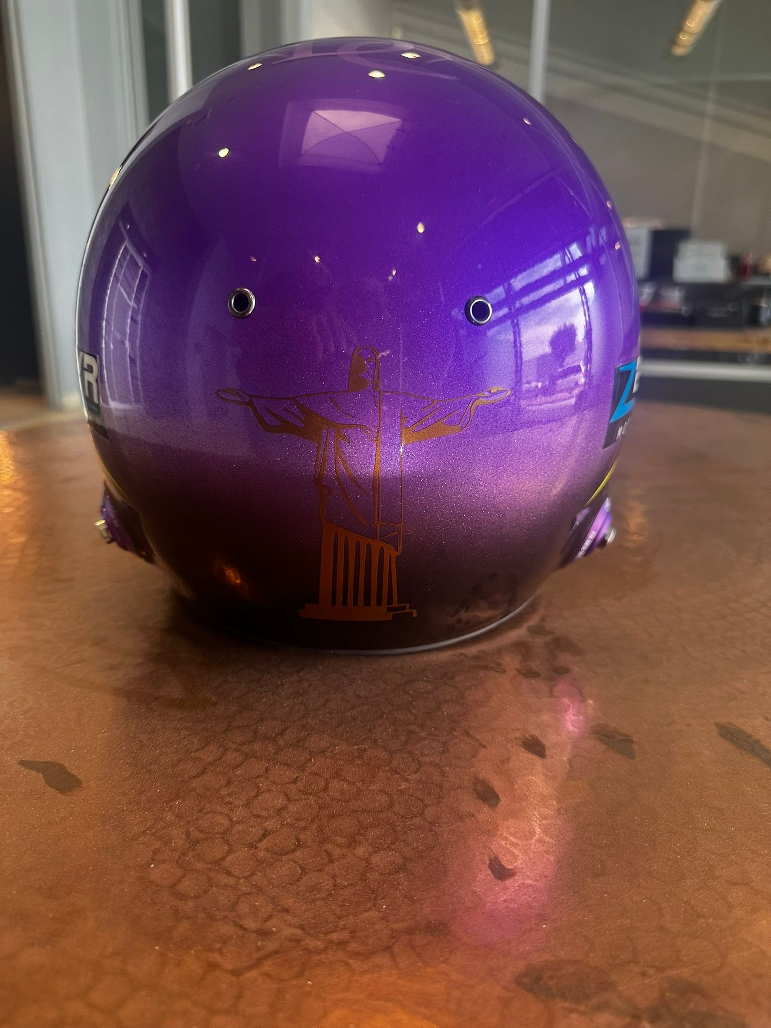 Purple bowling ball with finger holes on a wooden lane table surface