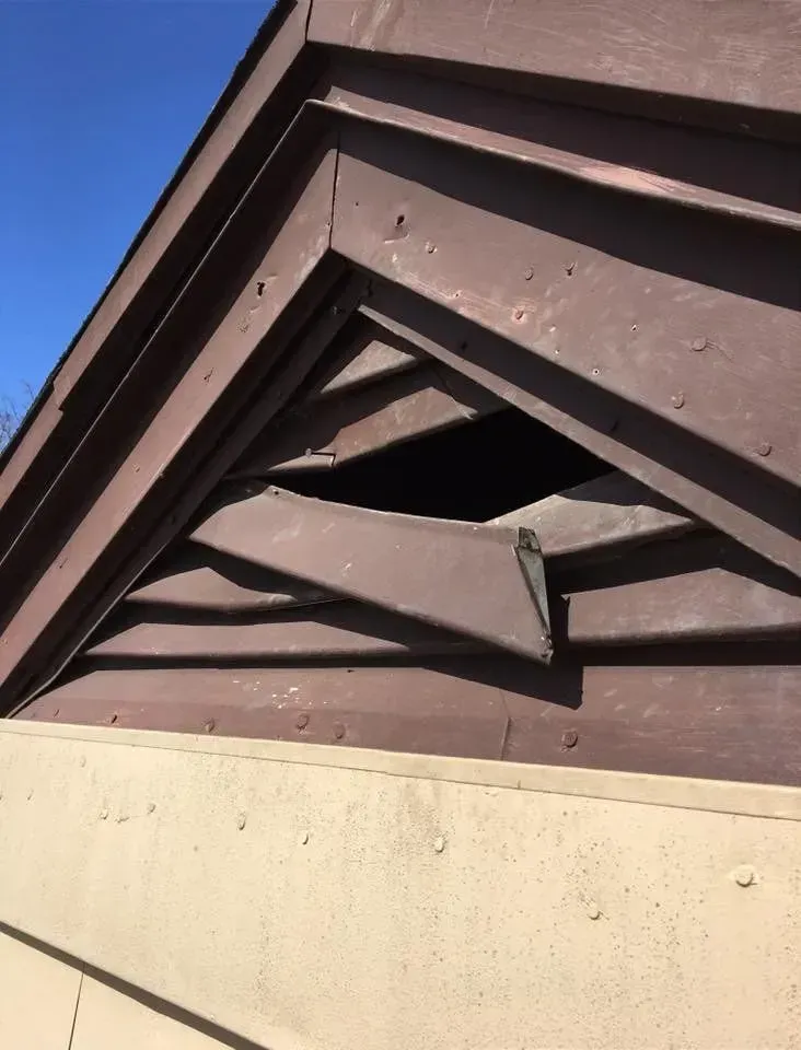Brown wooden building with triangular cutout in the upper section.