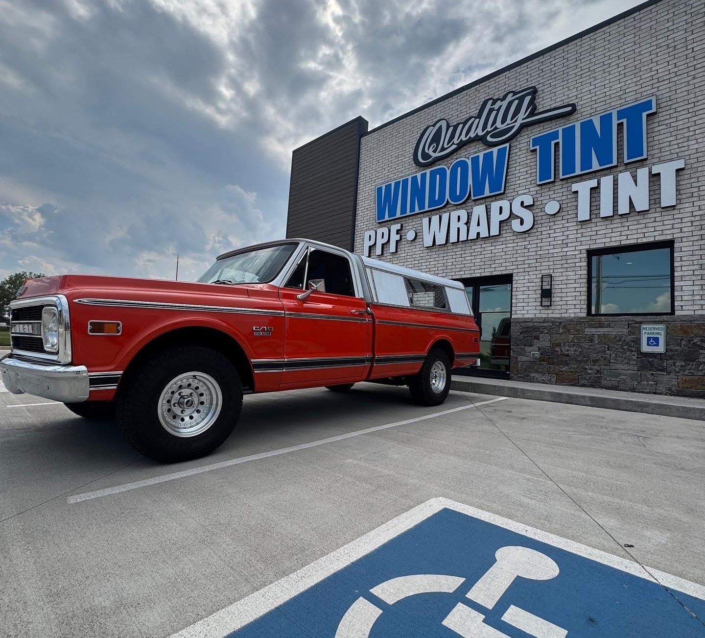 Red pickup truck parked in front of a business with 