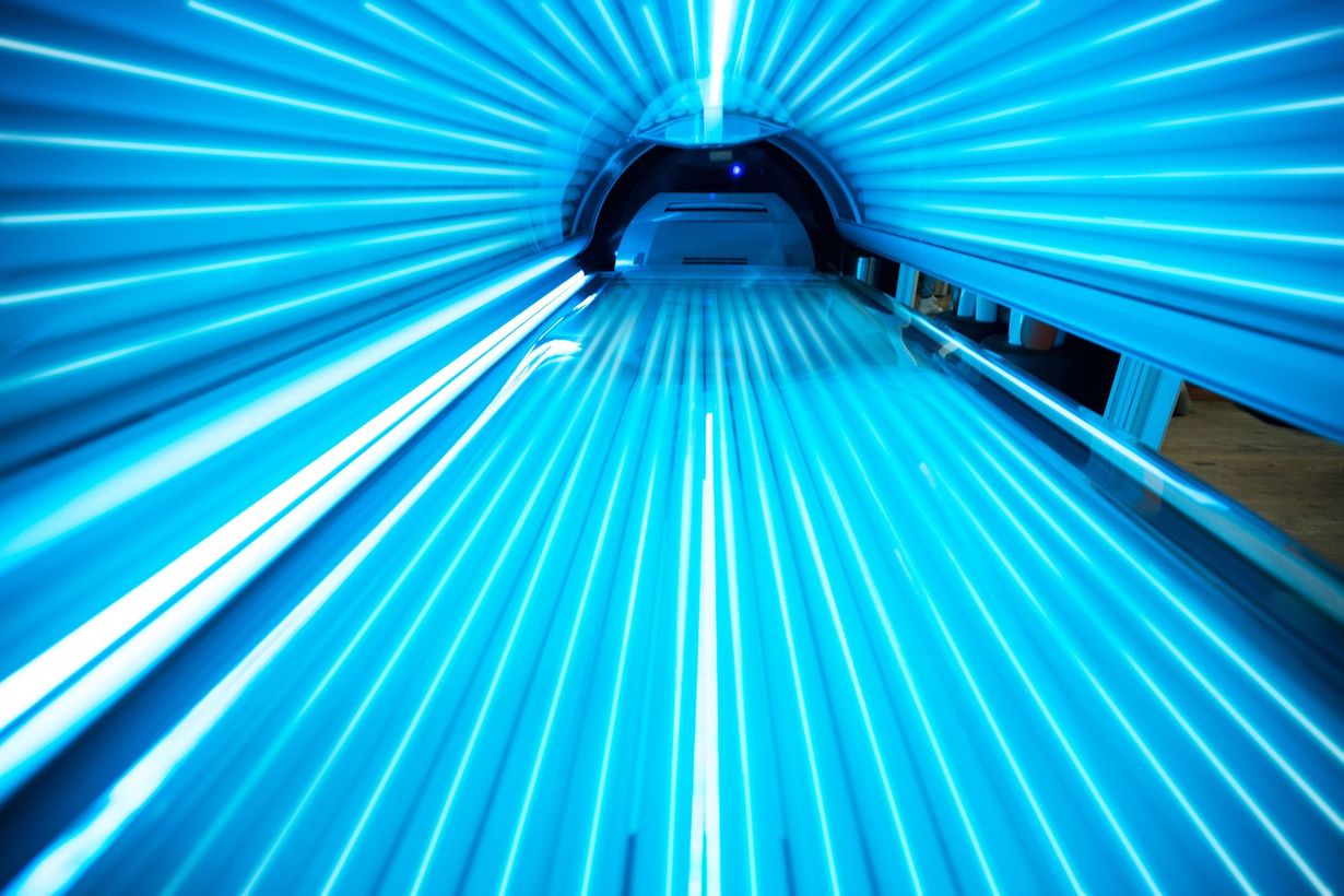 Tanning bed interior glowing with bright blue lights.