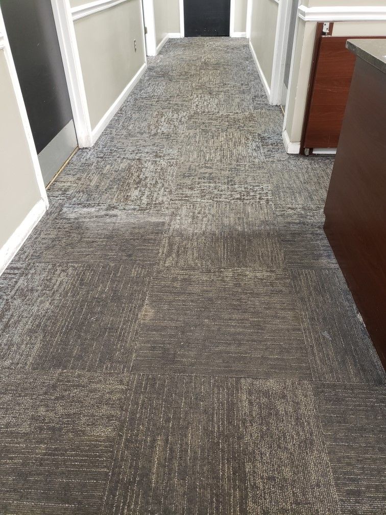 A long hallway with a carpeted floor in an office building.