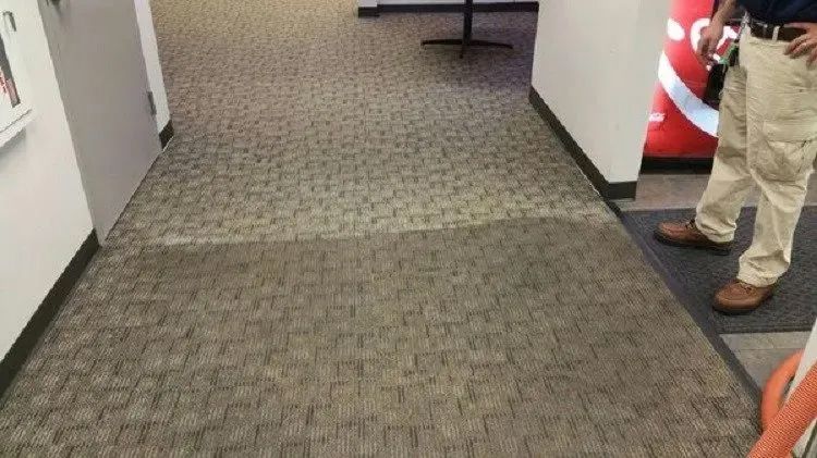 a man is standing in a hallway next to a coca cola machine