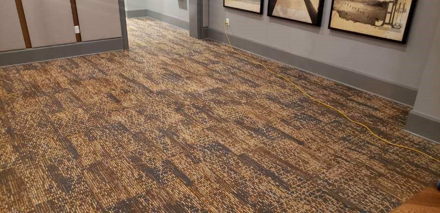 A hallway with a carpeted floor and pictures on the wall