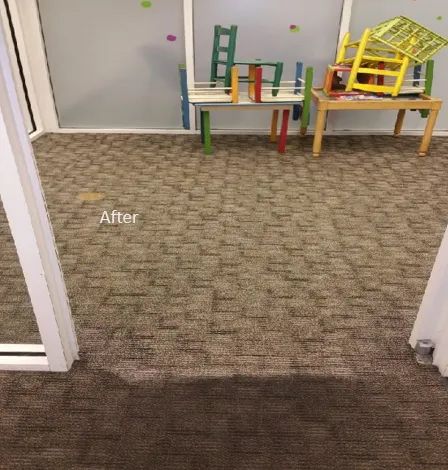 A room with a carpeted floor and a table and chairs in it