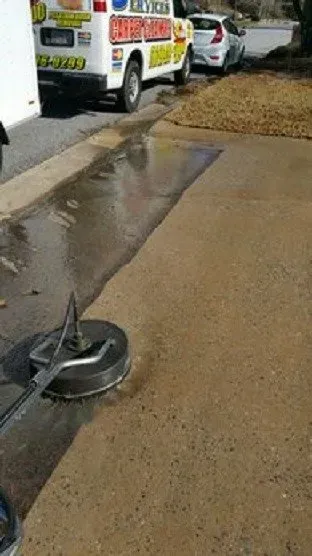 A person is cleaning a sidewalk with a machine