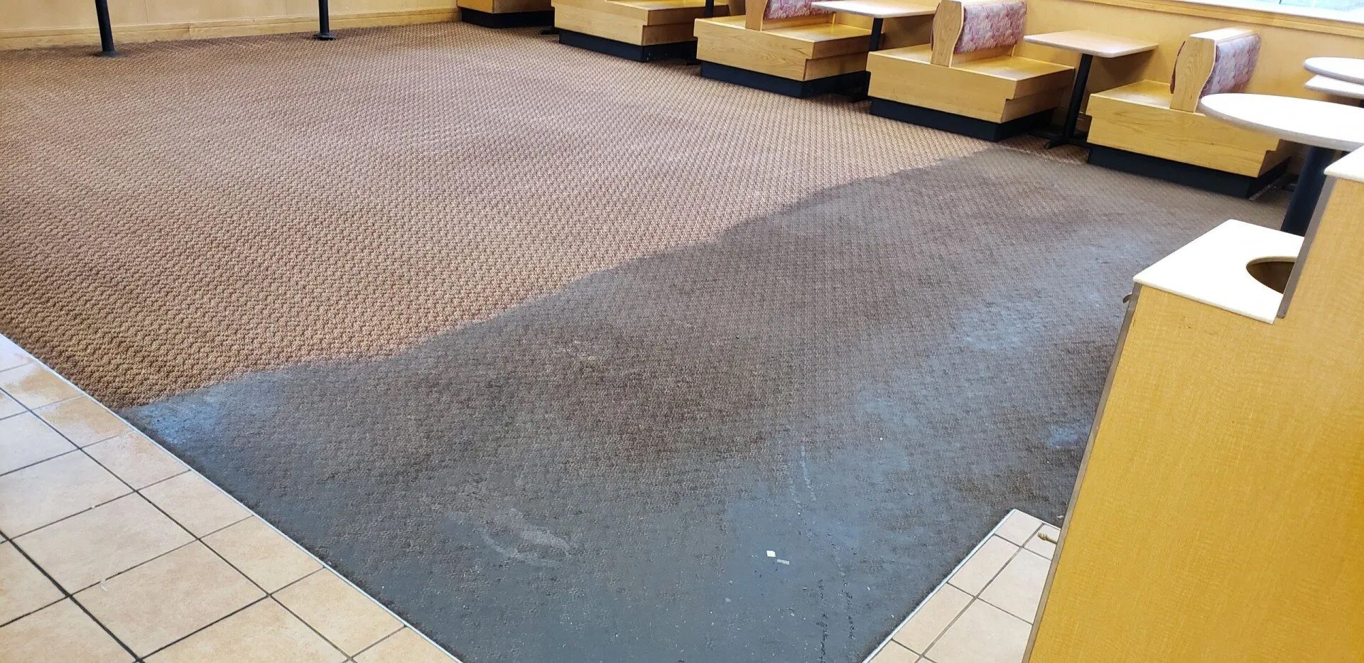 A restaurant with tables and chairs and a carpeted floor