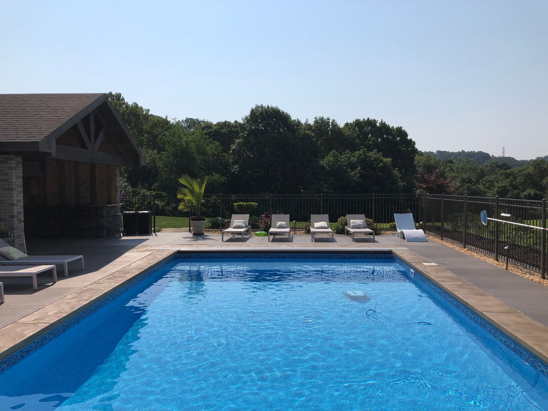 A large swimming pool surrounded by chairs on a sunny day