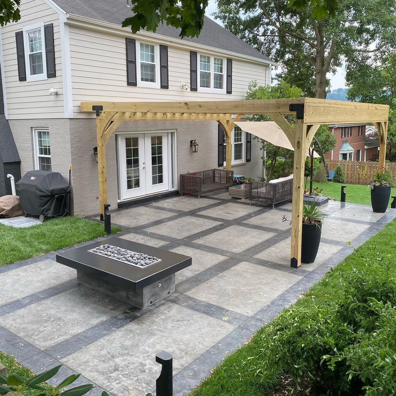 A house with a pergola and a table in front of it