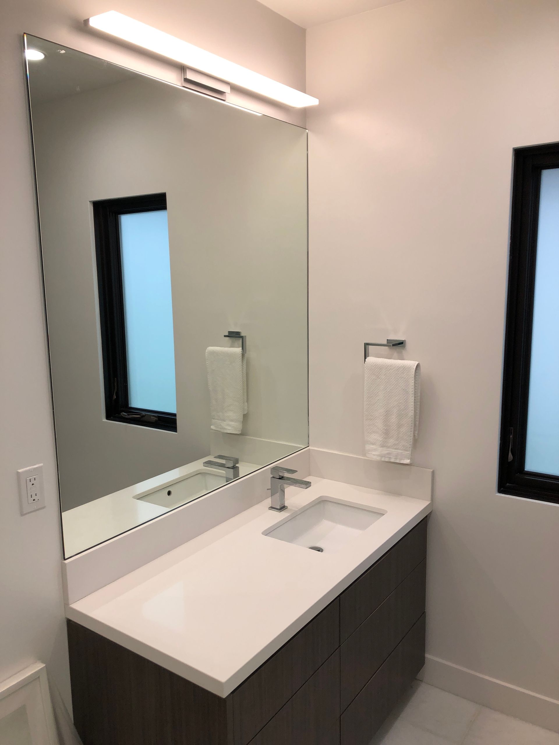 A bathroom with a sink , mirror and toilet.
