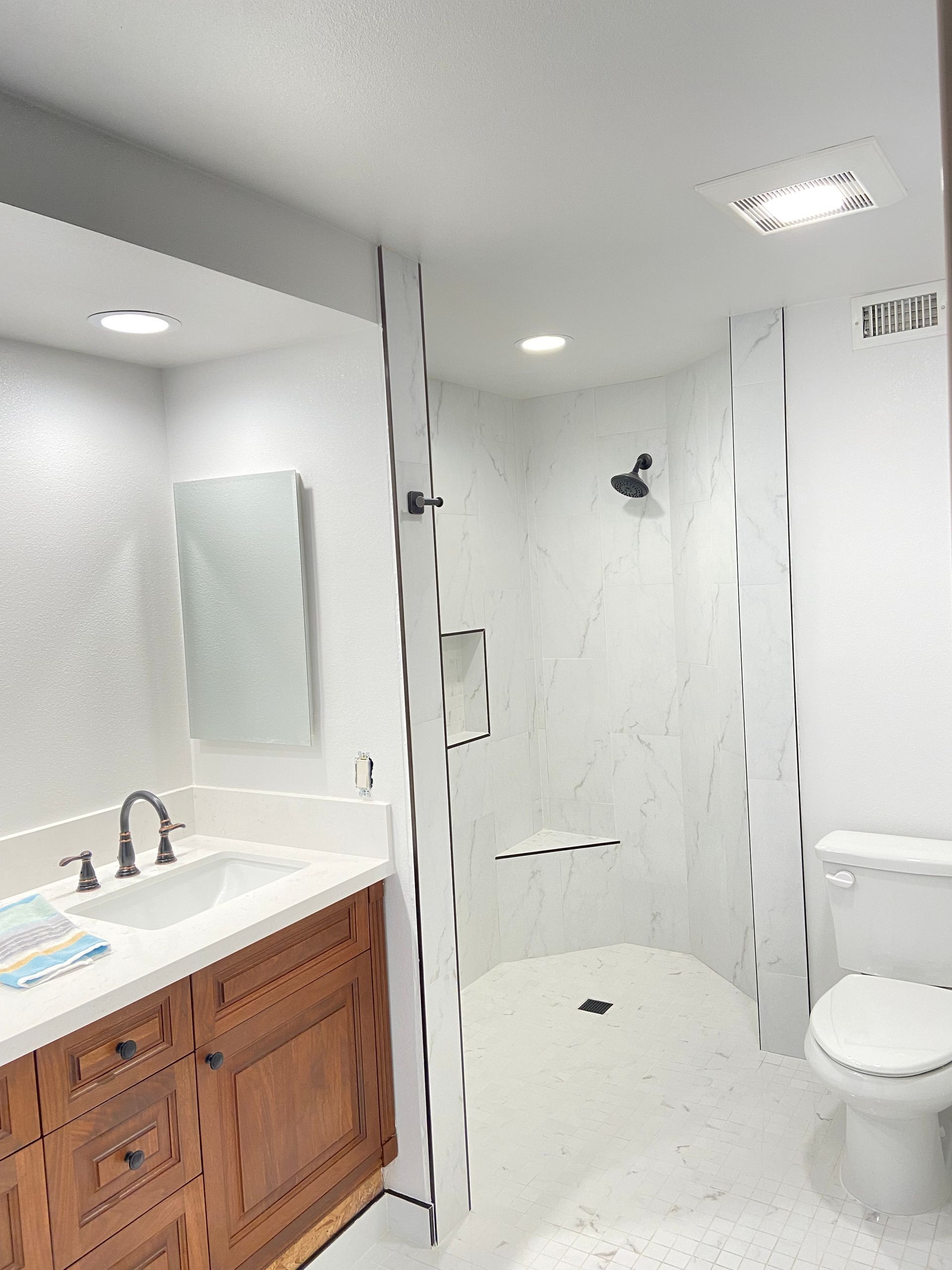 A bathroom with a sink , toilet and shower.