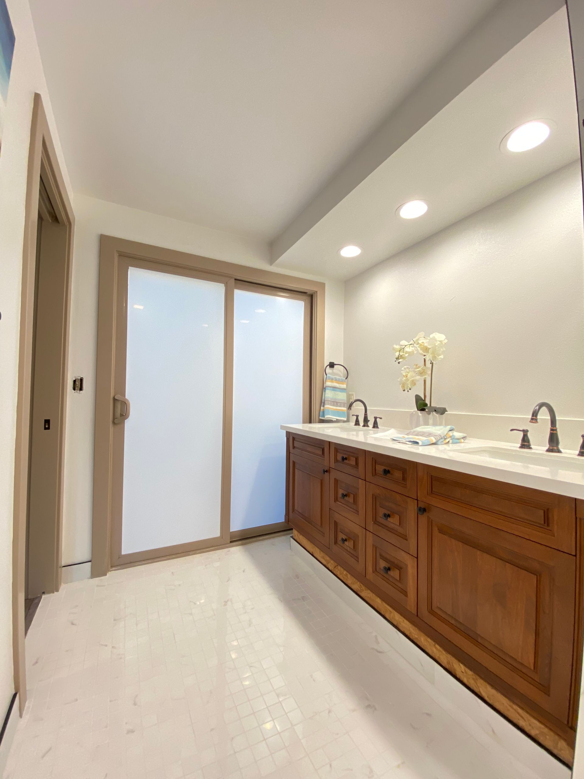 A bathroom with two sinks and a sliding glass door
