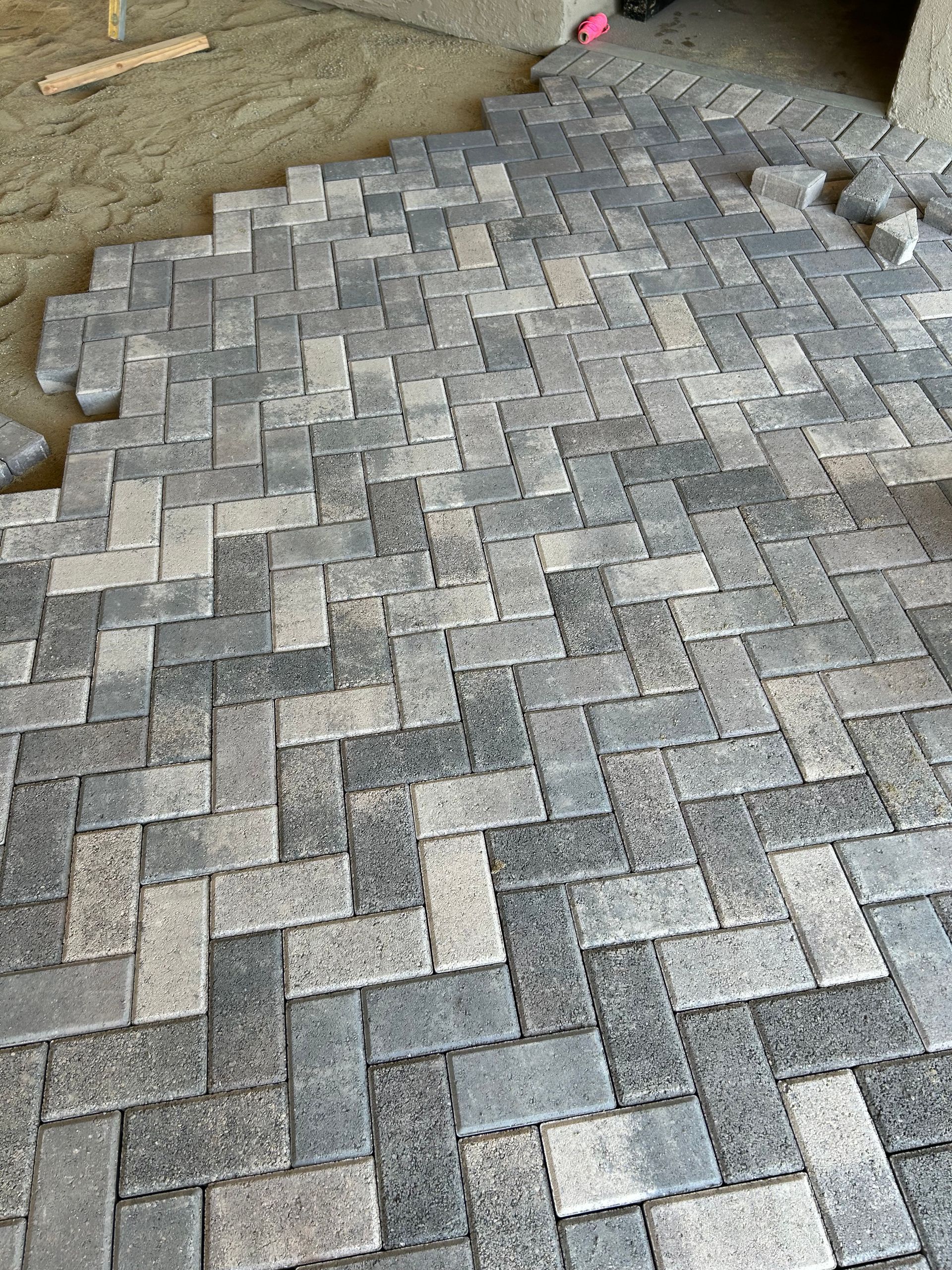 Herringbone pattern brickwork in various shades of gray and tan.