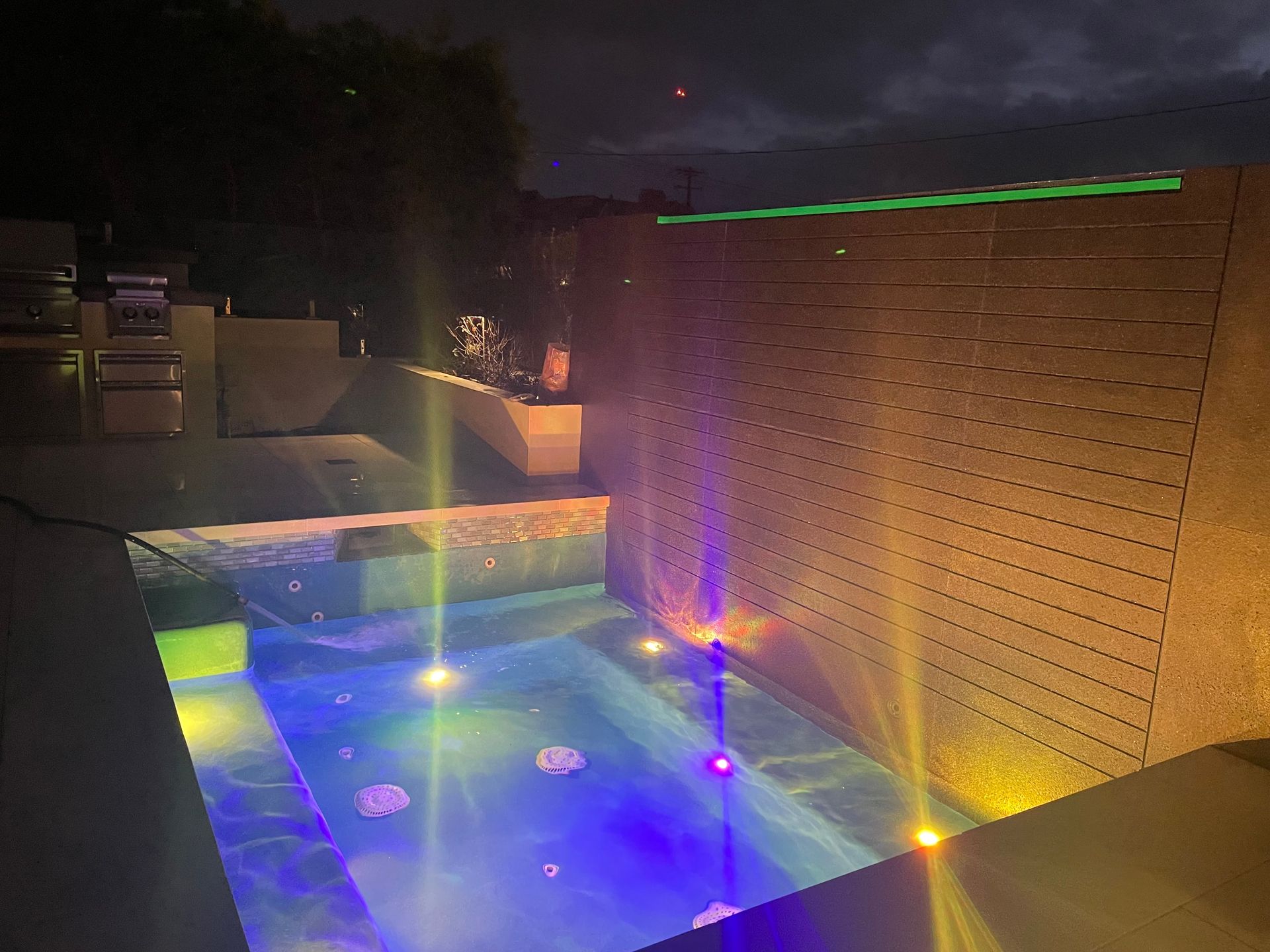 A large swimming pool is lit up at night.