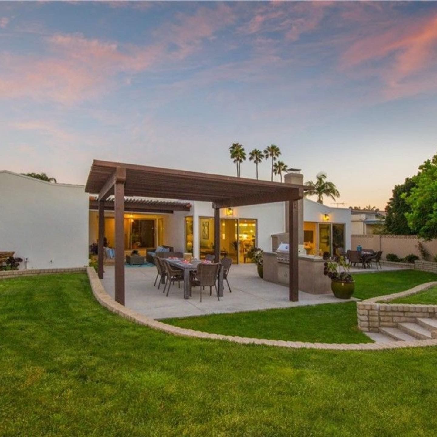 A backyard with a pergola and a table and chairs