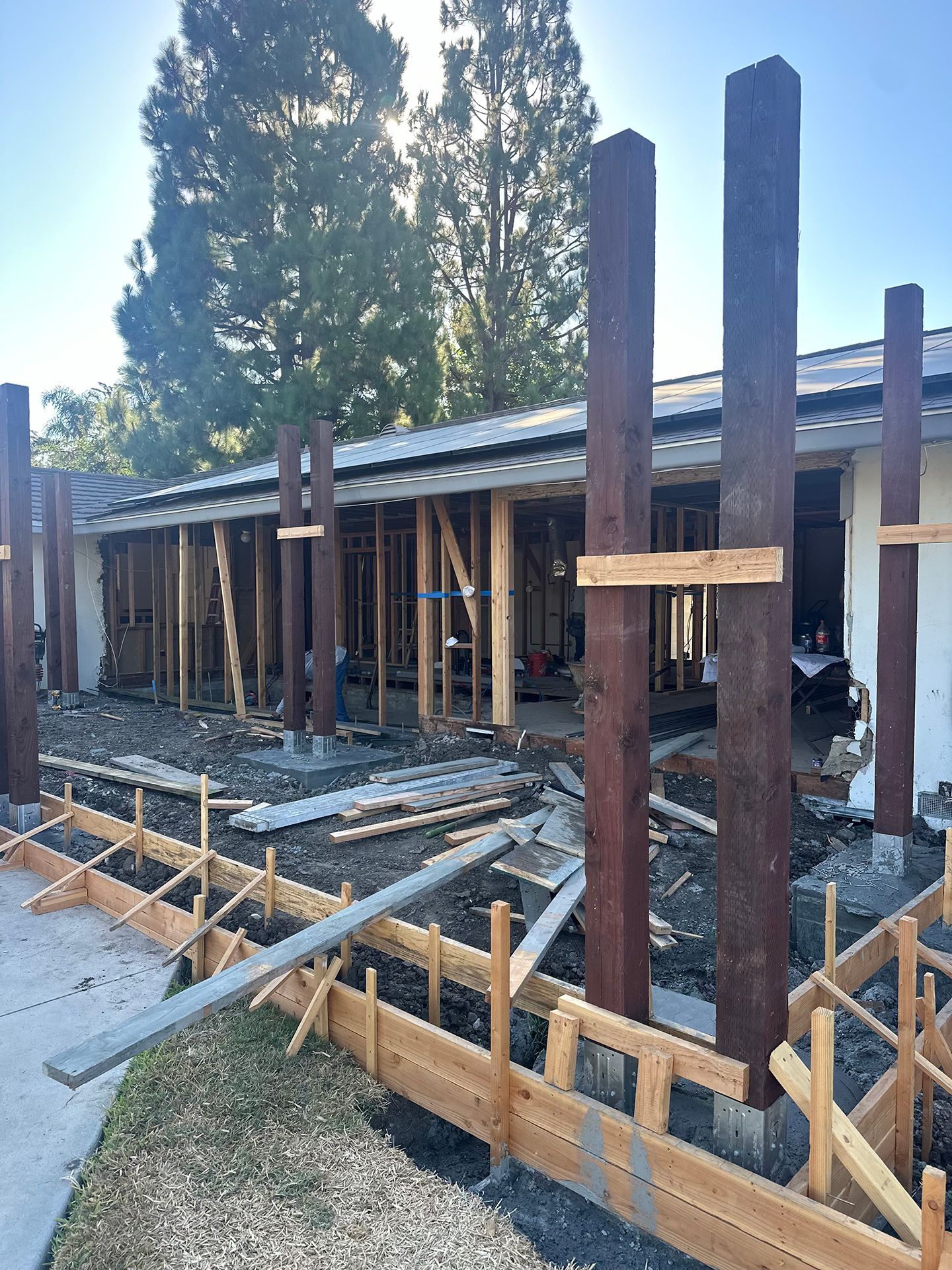 A wooden fence is being built in front of a building under construction