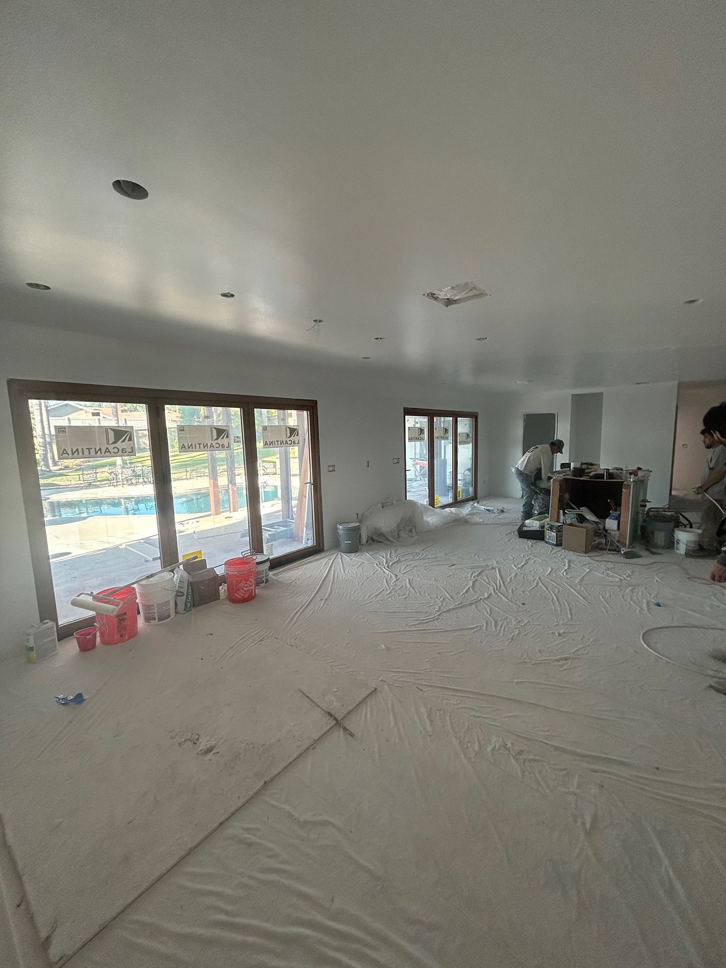 A large room with a lot of windows is being painted