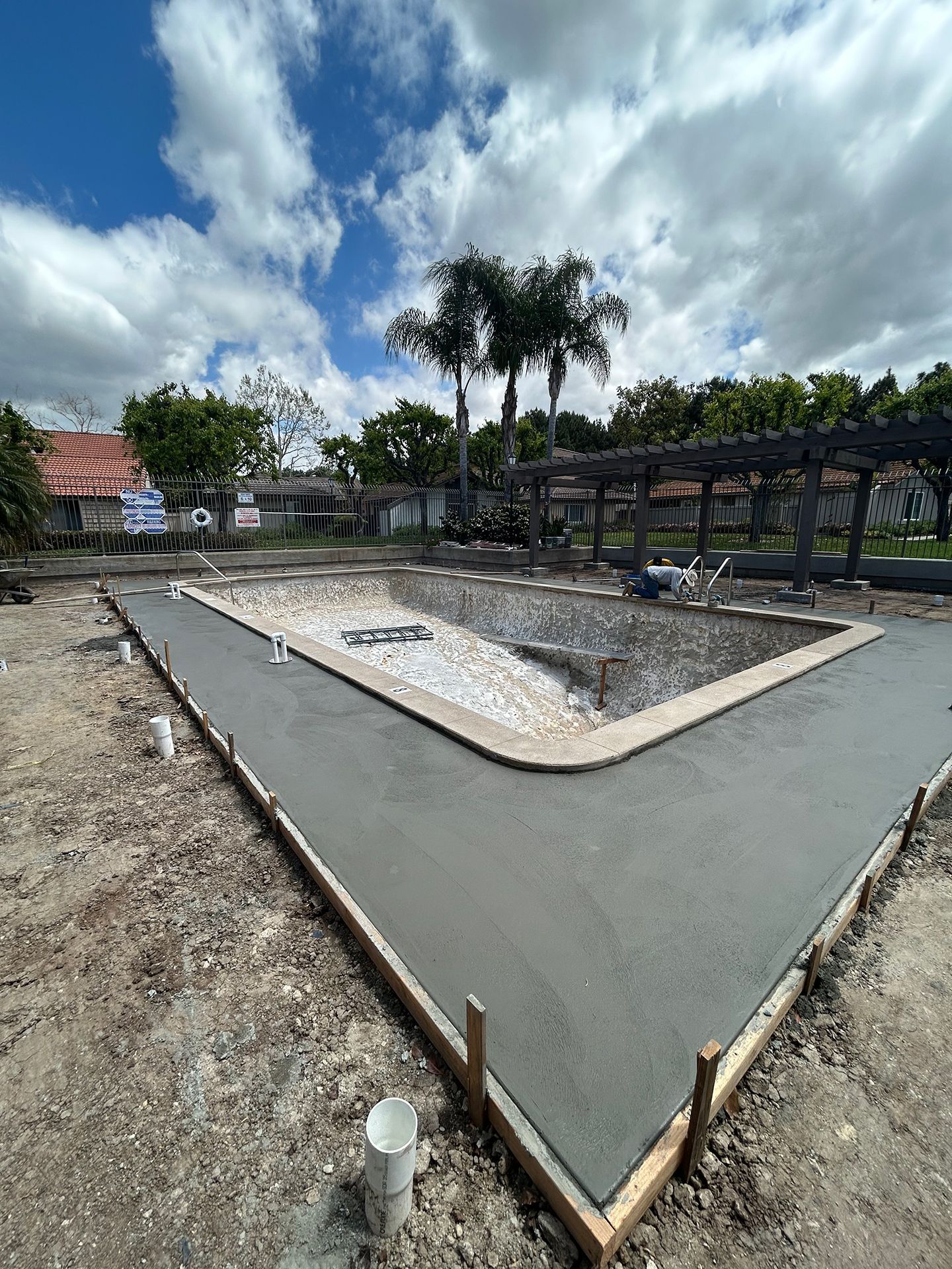 A swimming pool is being built in the backyard of a house