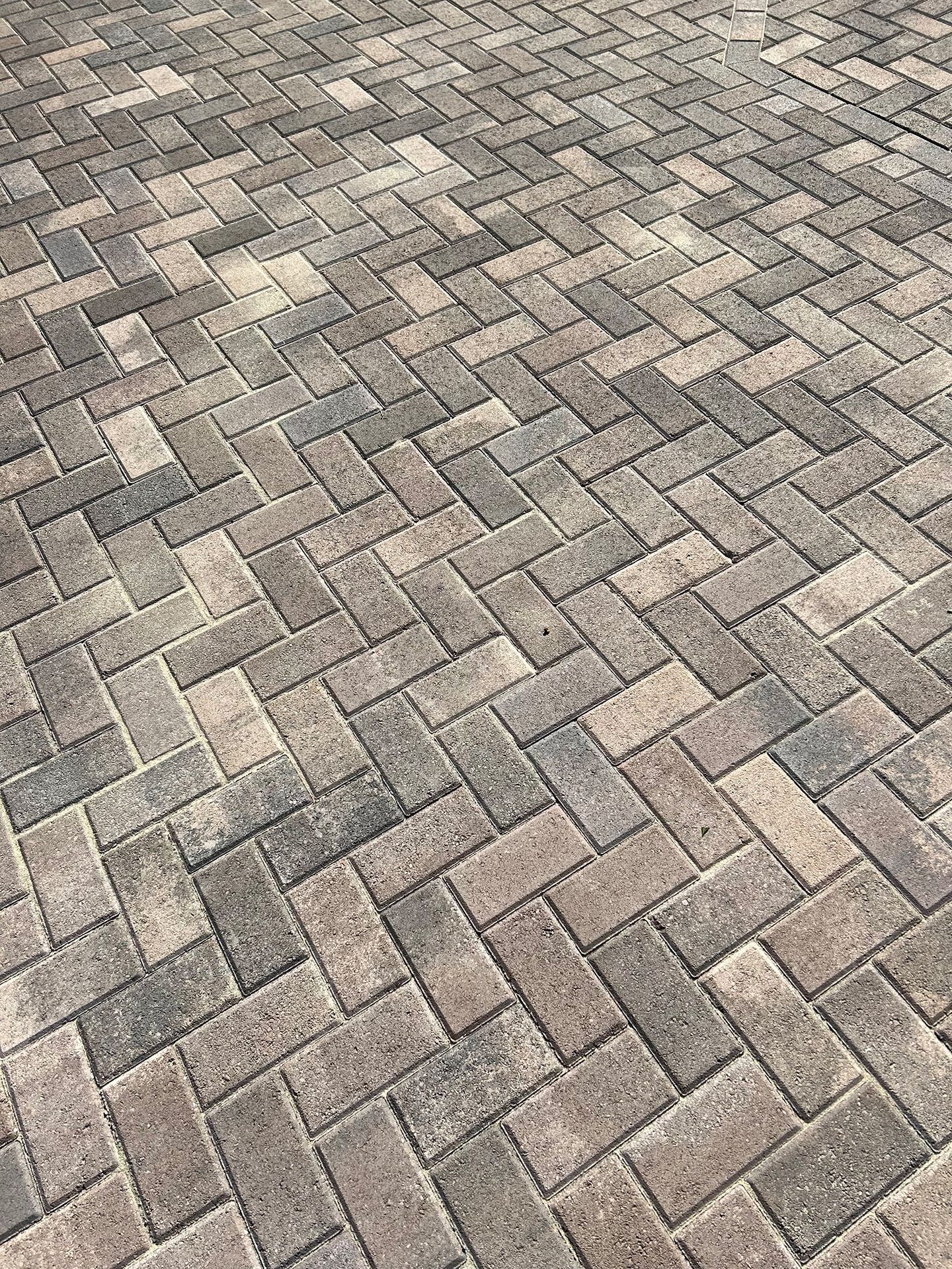 Herringbone brick pavers in shades of gray and tan.