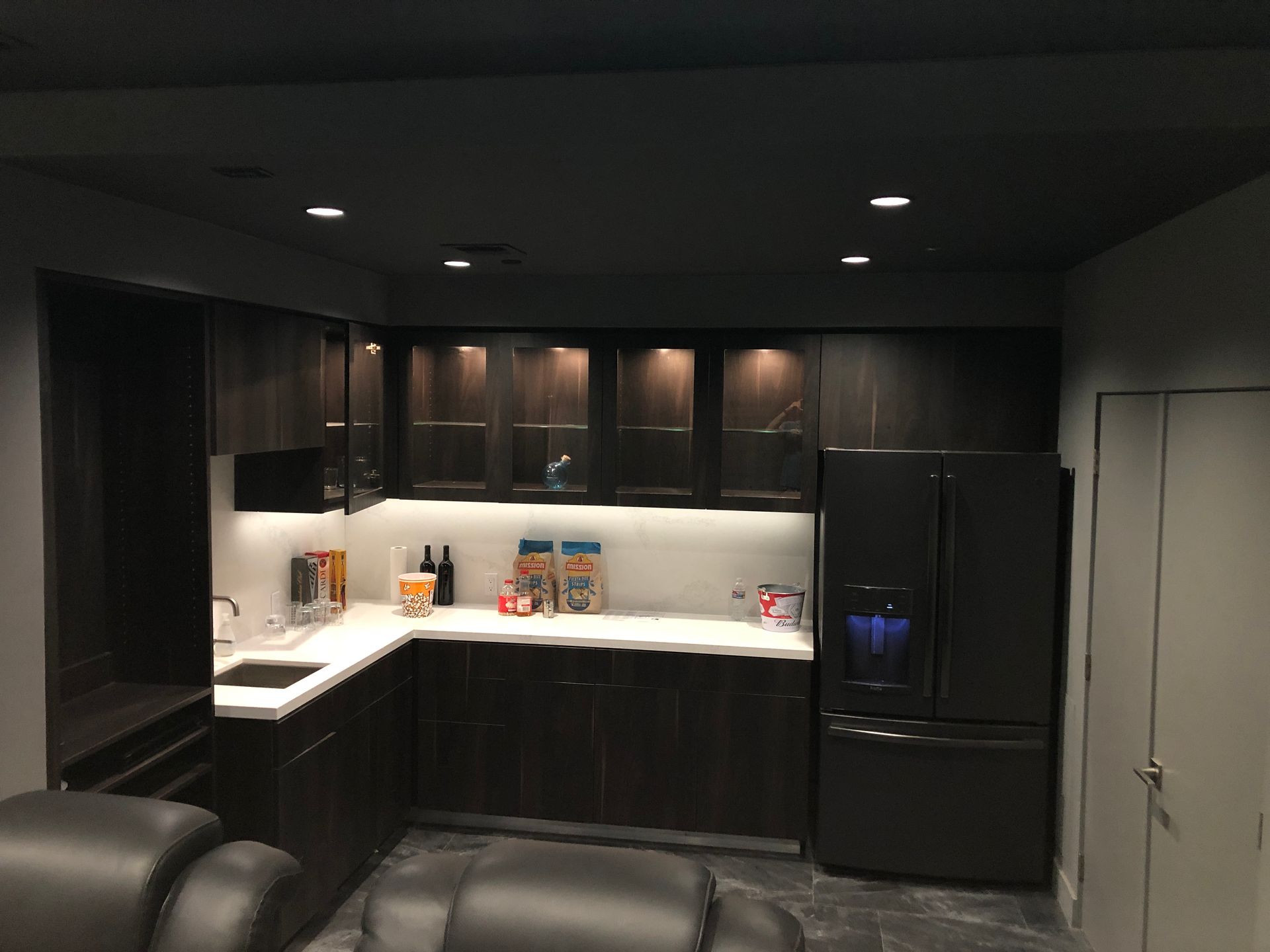 A kitchen with black cabinets and a black refrigerator