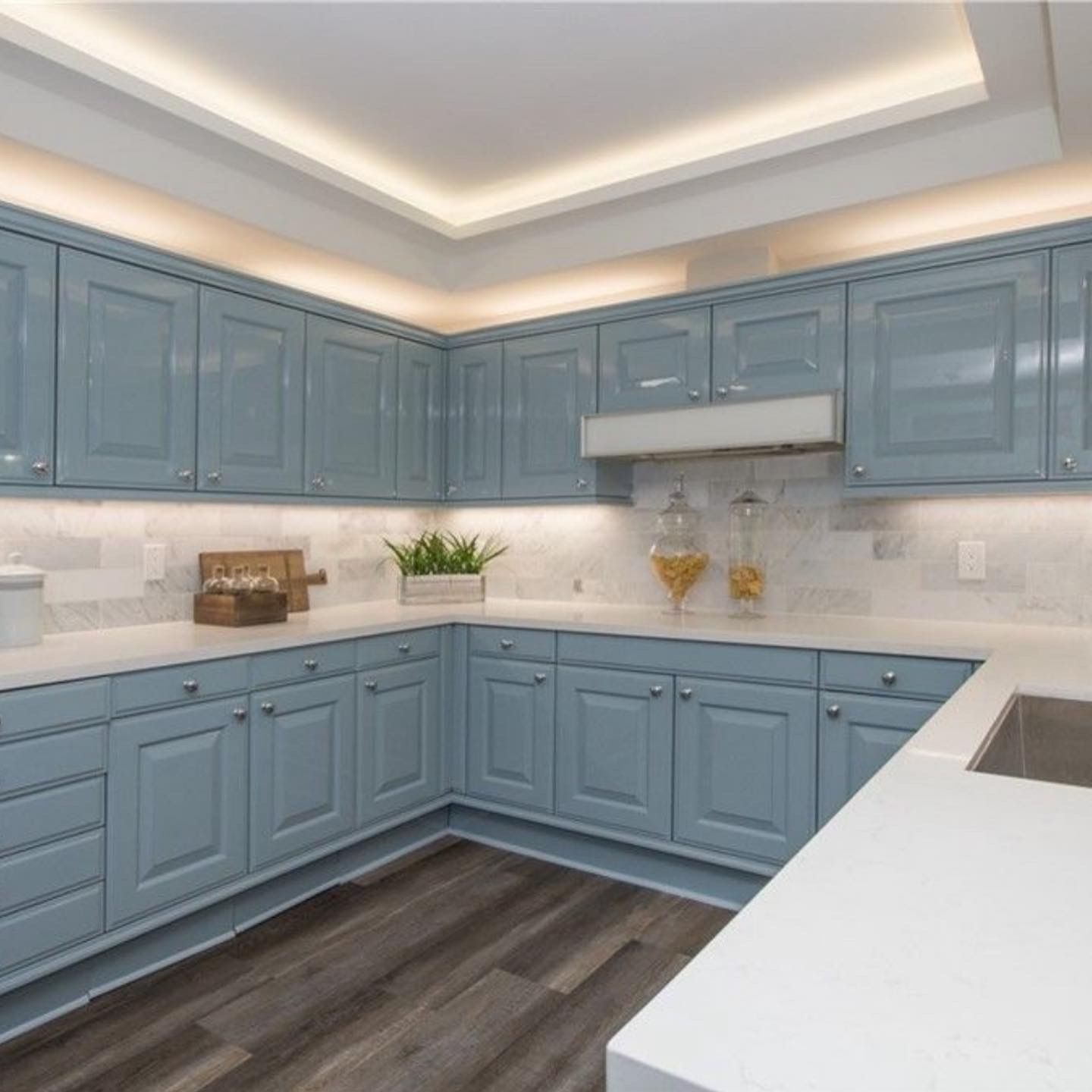 A kitchen with blue cabinets and white counter tops
