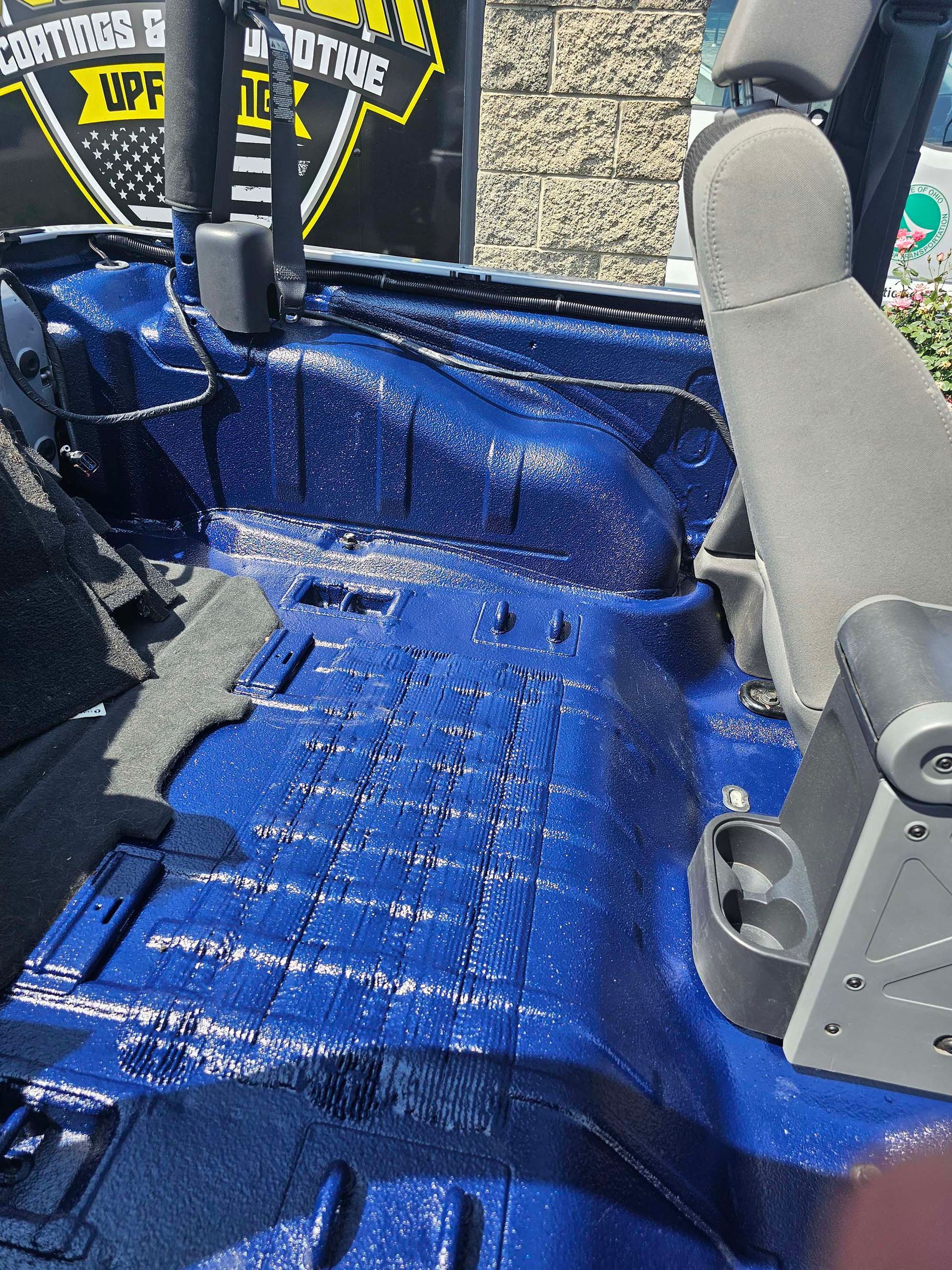 The inside of a blue jeep is covered in blue paint