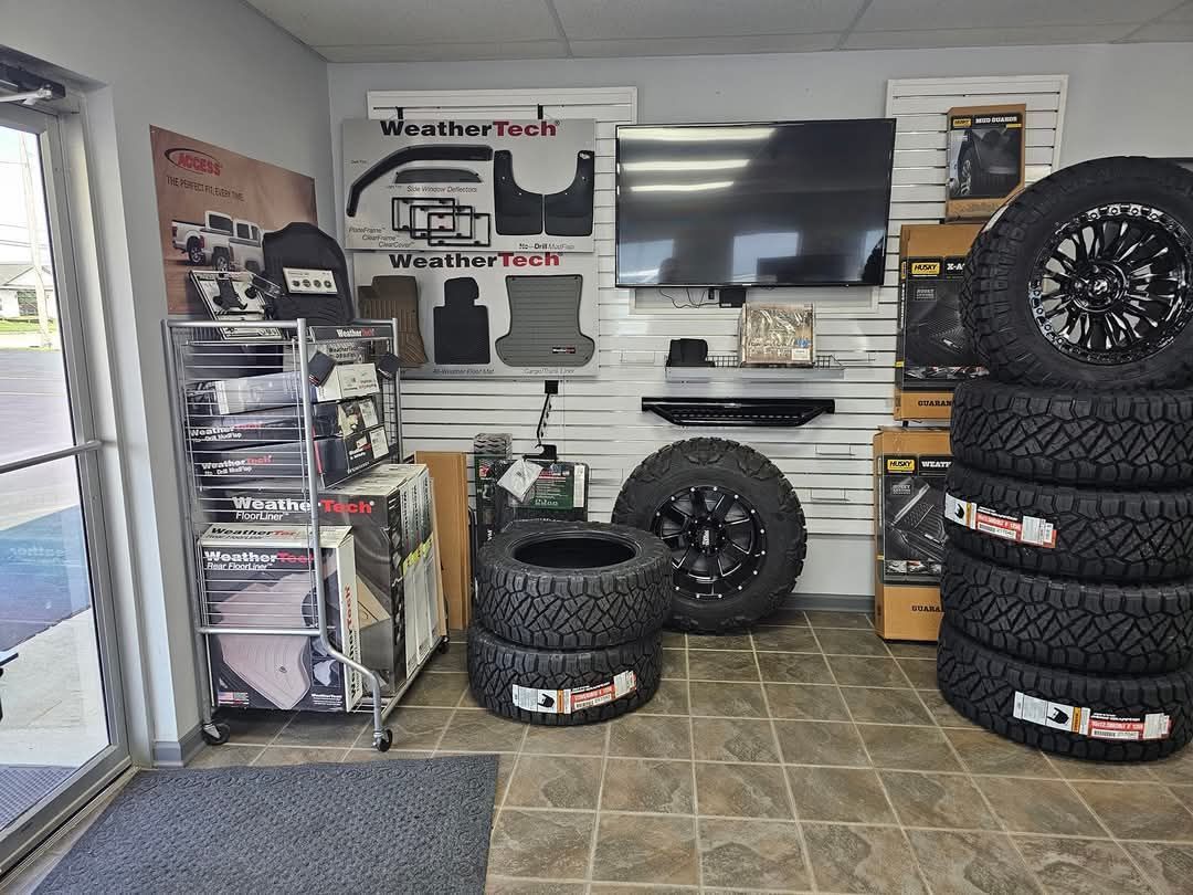 A room filled with tires , wheels , and a flat screen tv.