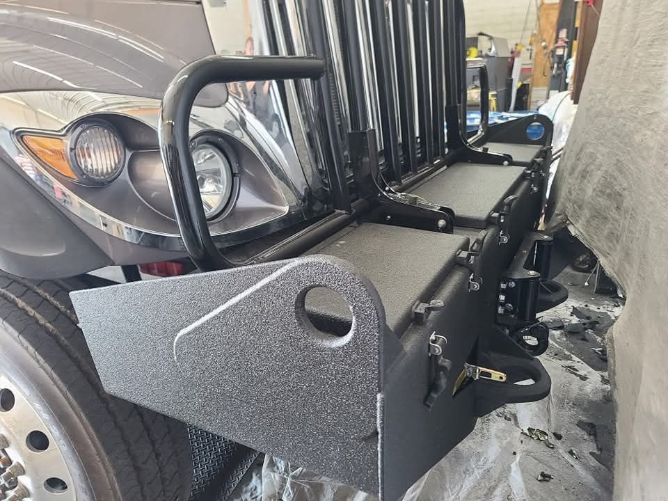A truck with a bumper on it is parked in a garage.