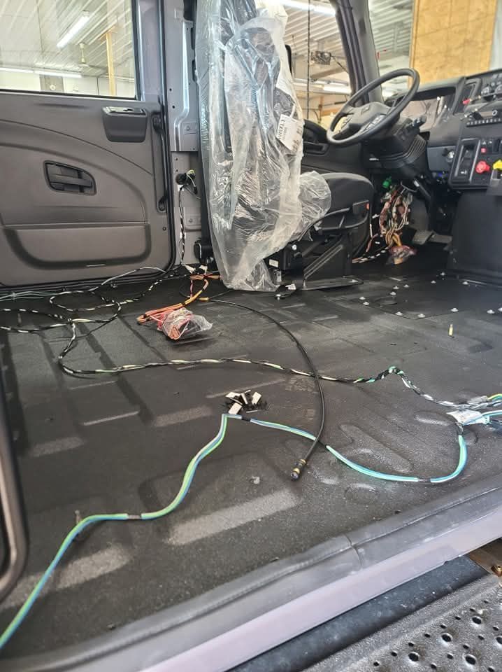 The inside of a truck with a lot of wires coming out of it.
