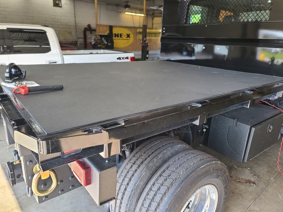 A flatbed truck is sitting in a garage.