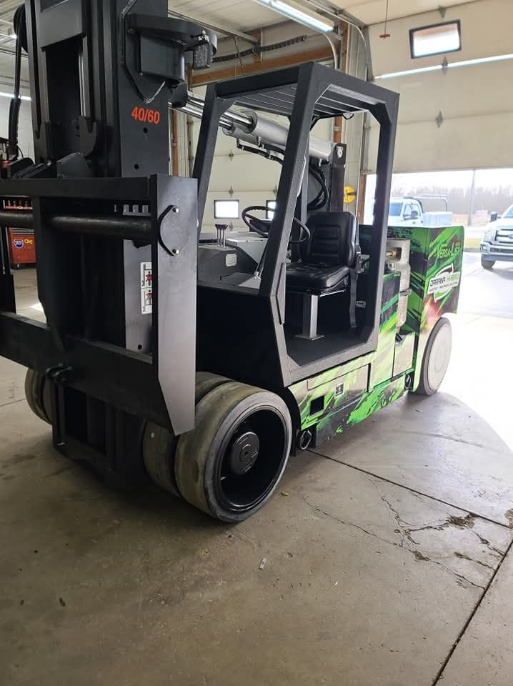 A forklift is parked in a garage next to a garage door.