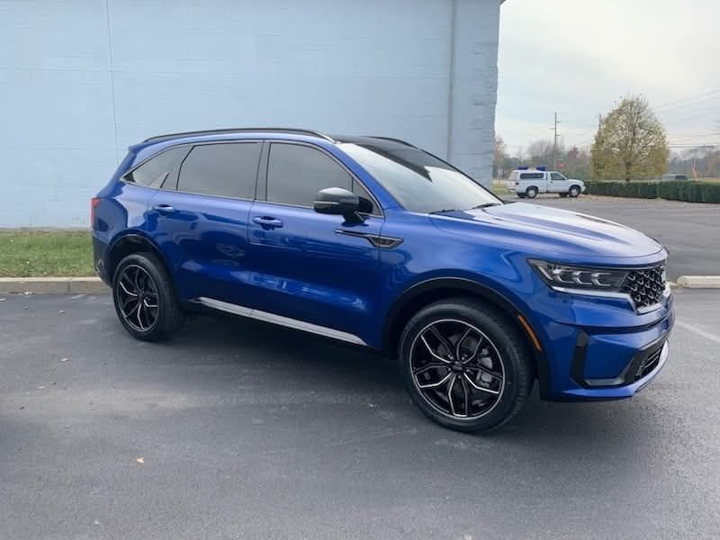 A blue suv is parked in a parking lot in front of a building.