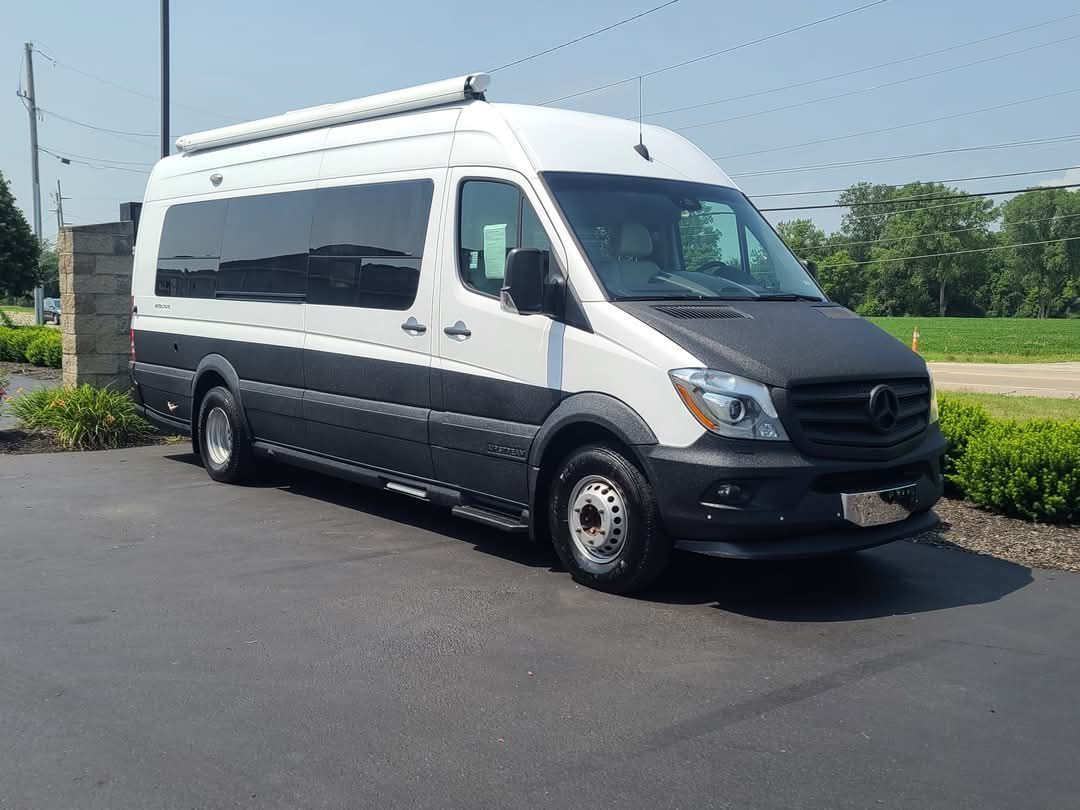 A white and black van is parked in a parking lot.