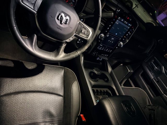 Interior view of a black Ram truck: dashboard, steering wheel, center console, leather seats.