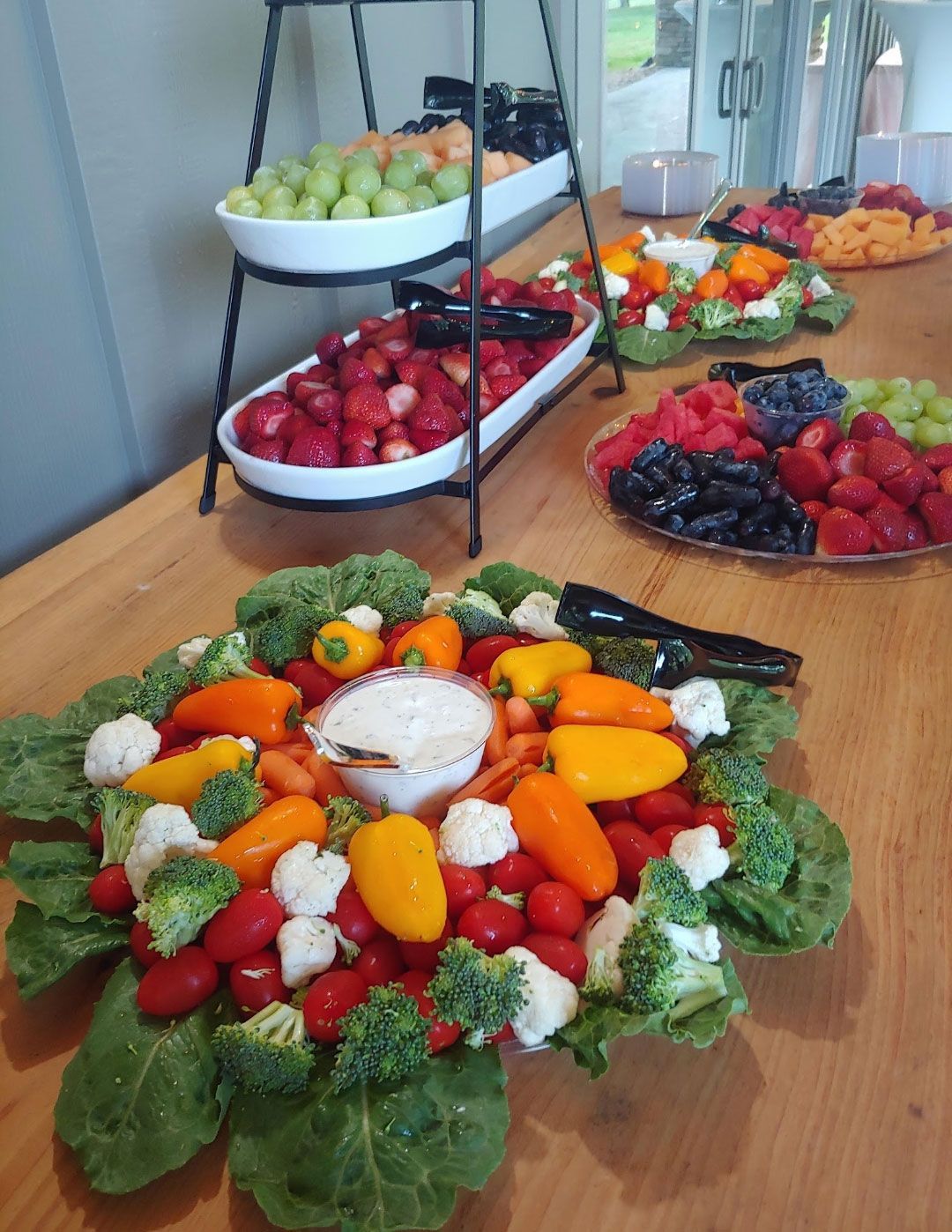 Fruit and vegetable platters on a wooden table. Strawberries, grapes, and mini peppers.