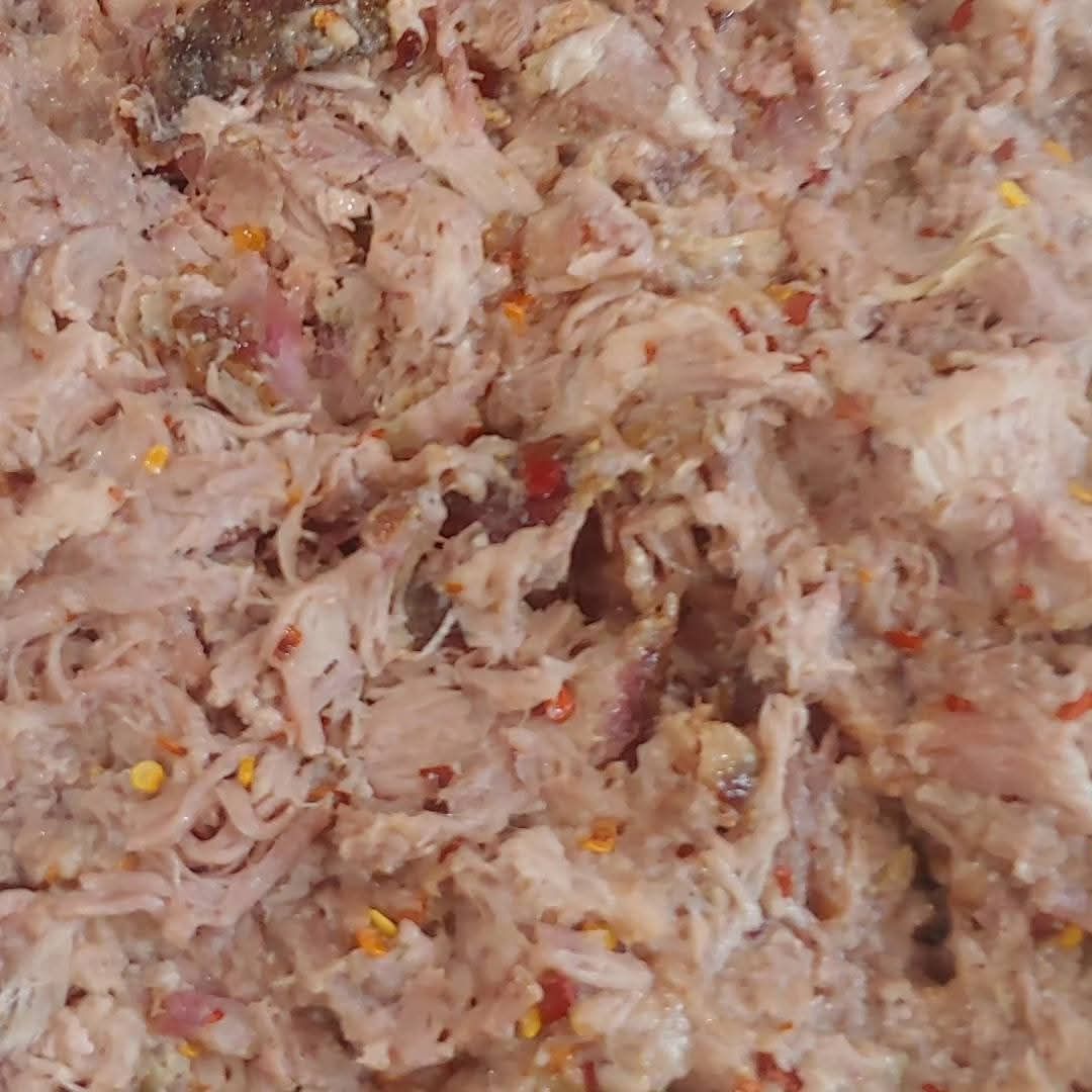 Shredded meat mixture with red pepper flakes.