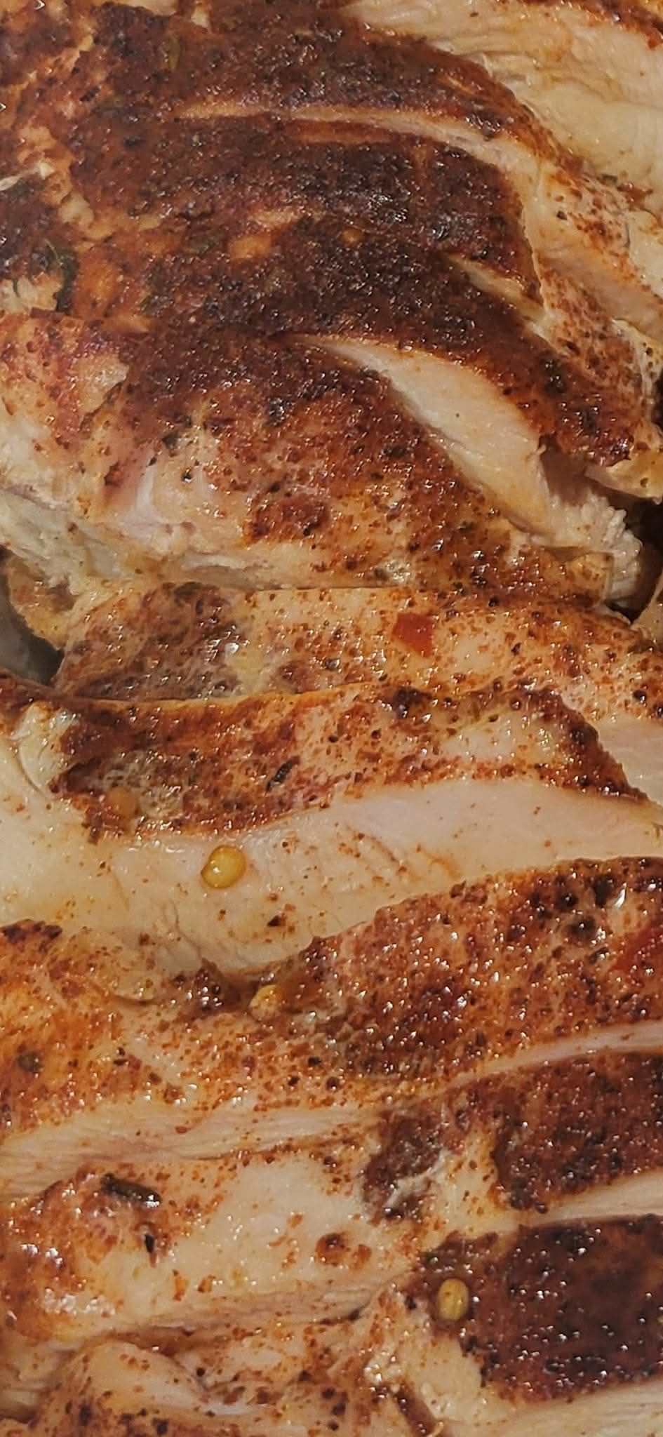 Sliced grilled chicken seasoned with spices.