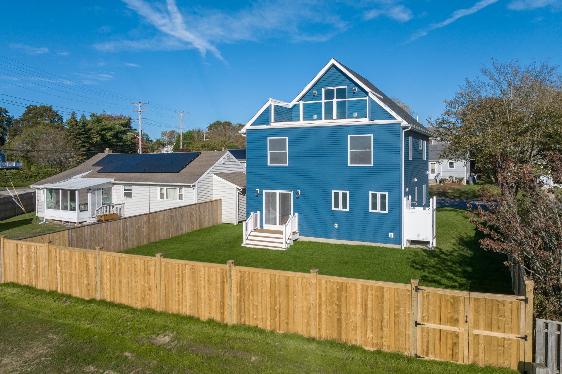 Wooden framing of a house under construction; exposed rafters and wall studs against a cloudy sky.