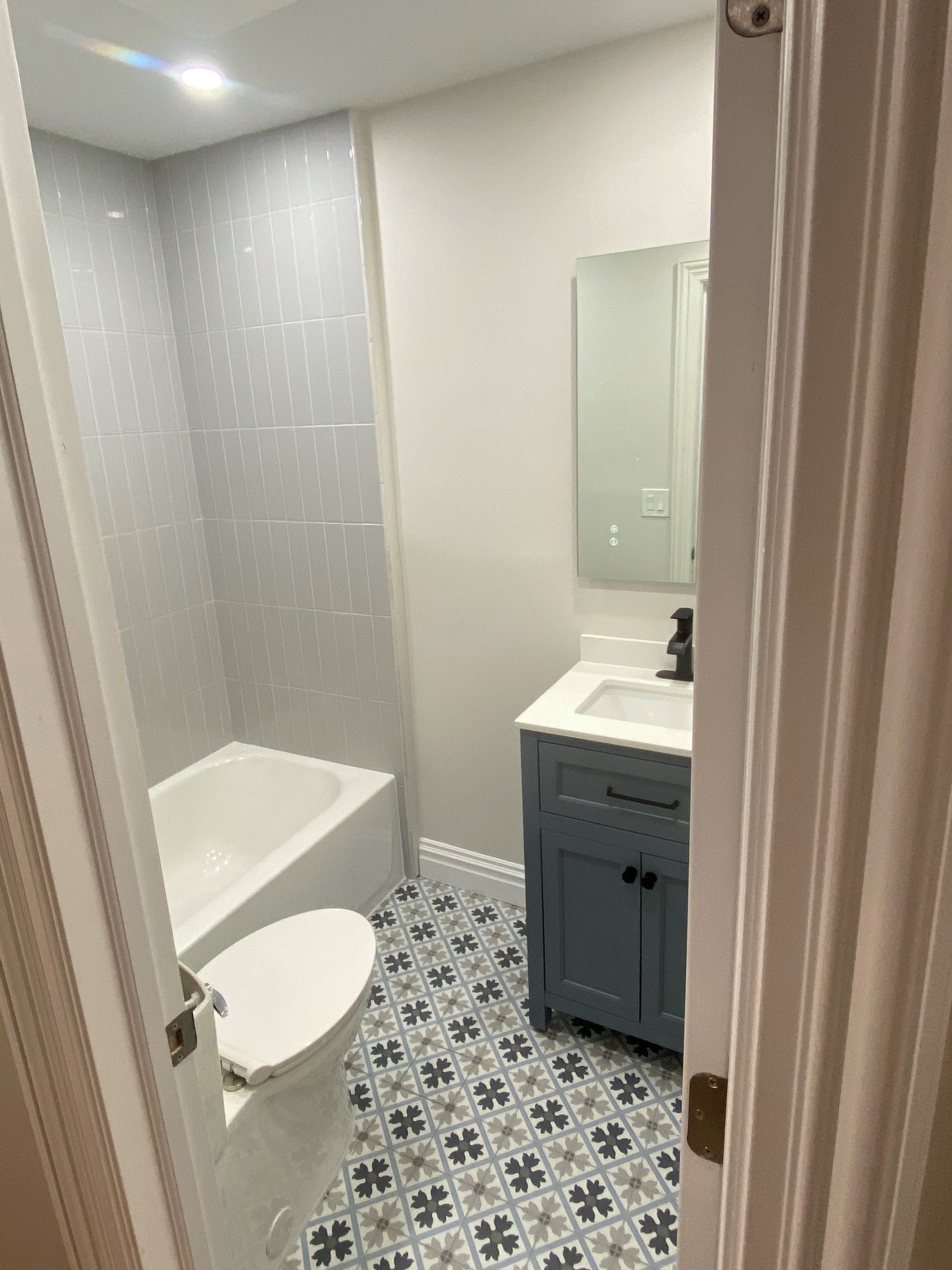 a bathroom with a toilet , sink , bathtub and mirror .