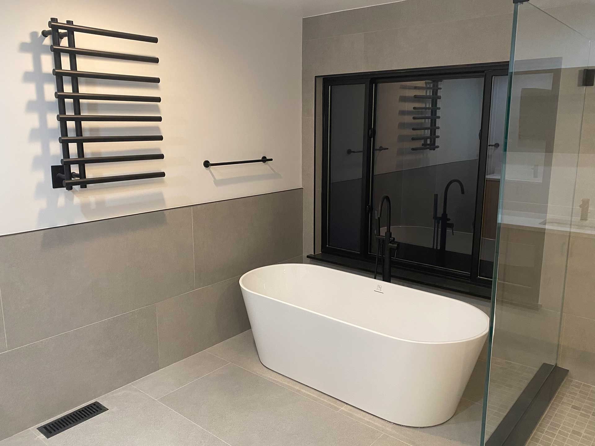 bathroom with a heated towel rack and a farmhouse-style bathtub