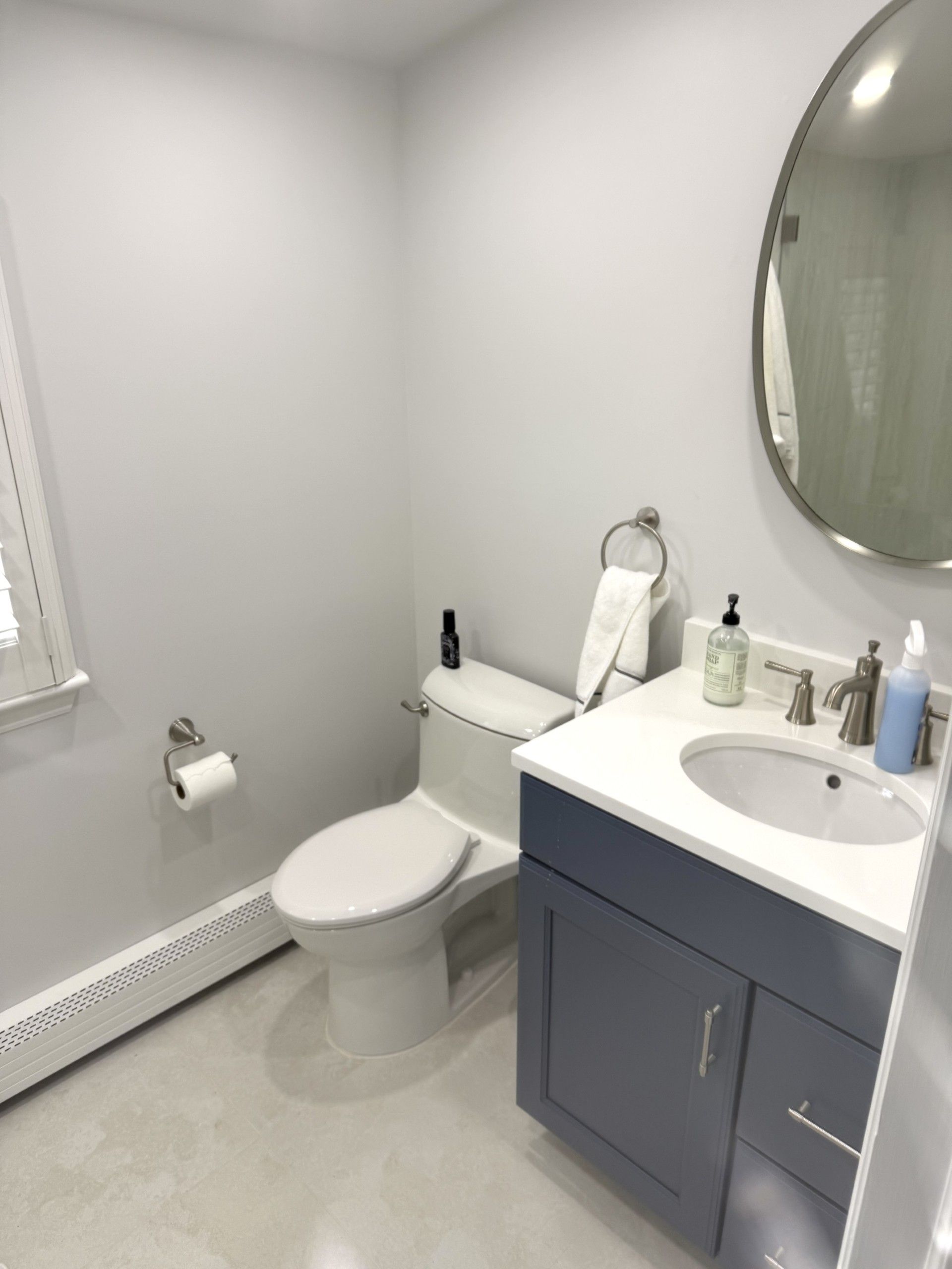A bathroom with a toilet a sink and a mirror