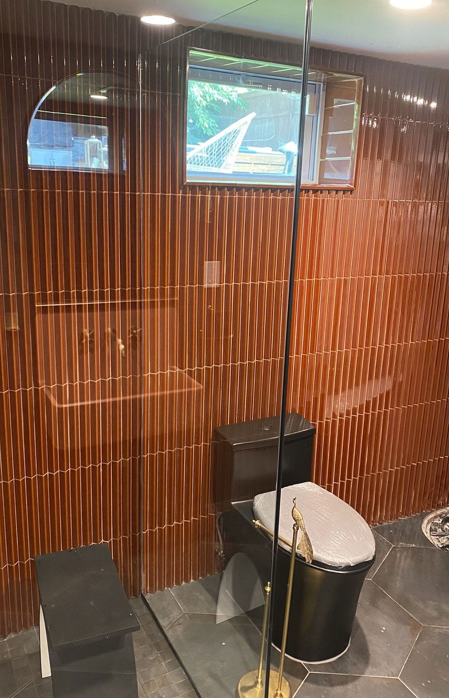 A bathroom with a toilet, shower, and window
