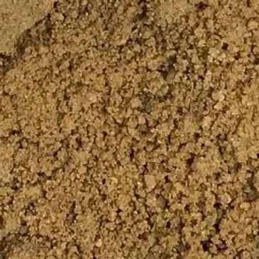 A close up of a pile of brown sand.