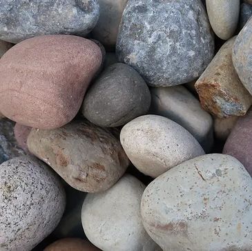 A pile of rocks of different sizes and colors are sitting on top of each other.