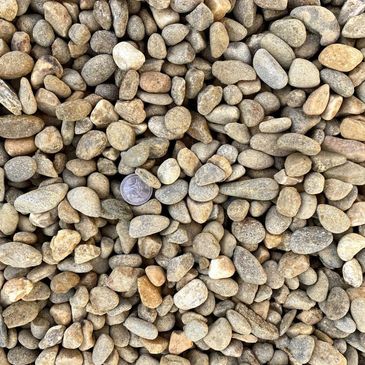A pile of rocks with a purple coin in the middle.