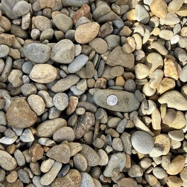 A pile of rocks with a quarter in the middle.