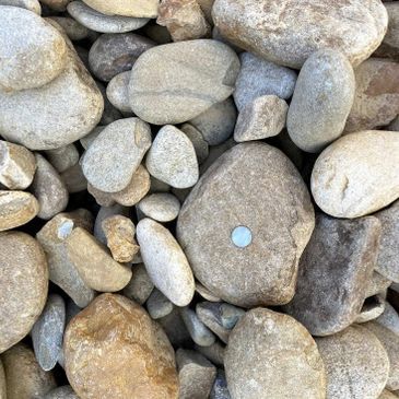A pile of rocks with a coin in the middle of them.